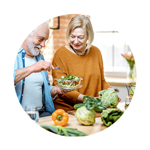 Couple de seniors cuisinant des fruits et légumes
