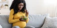 Jeune femme enceinte mangeant une salade de légumes