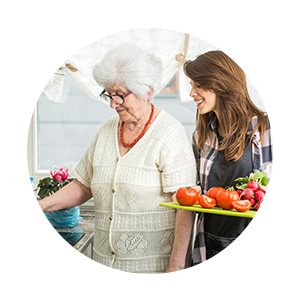 Jeune femme cuisinant avec sa grand-mère, maladie d'Alzheimer