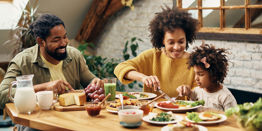 Famille mangeant une alimentation saine à table - Equation Nutrition - Aprifel