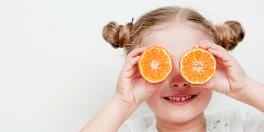 Education alimentaire à l'école - enfant jouant avec une orange
