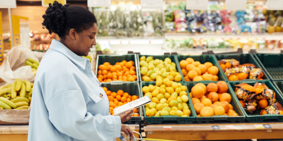 Femme en train d'acheter des fruits et légumes au supermarché
