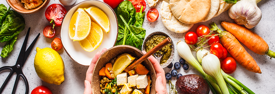 main tenant un bol contenant une variété de fruits et légumes, du tofu, des légumineuses, Alimentation durable EGEA - Aprifel